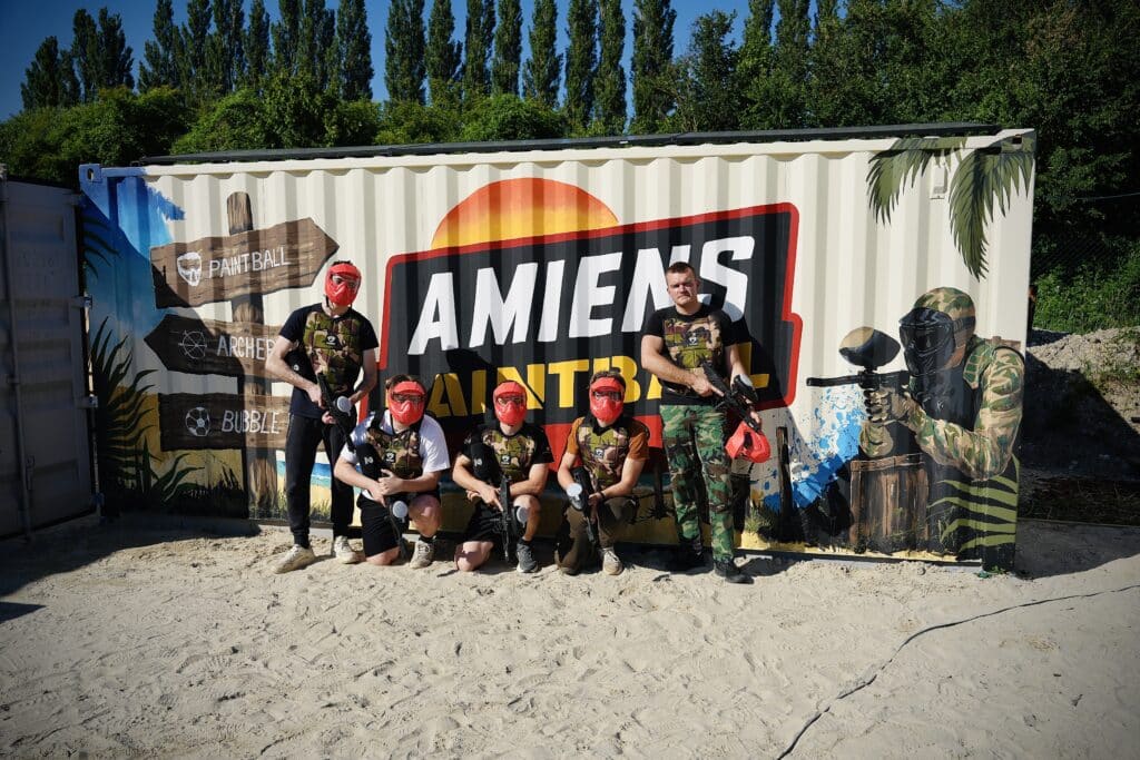 Une équipe de paintball posant devant le logo de Amiens Paintball