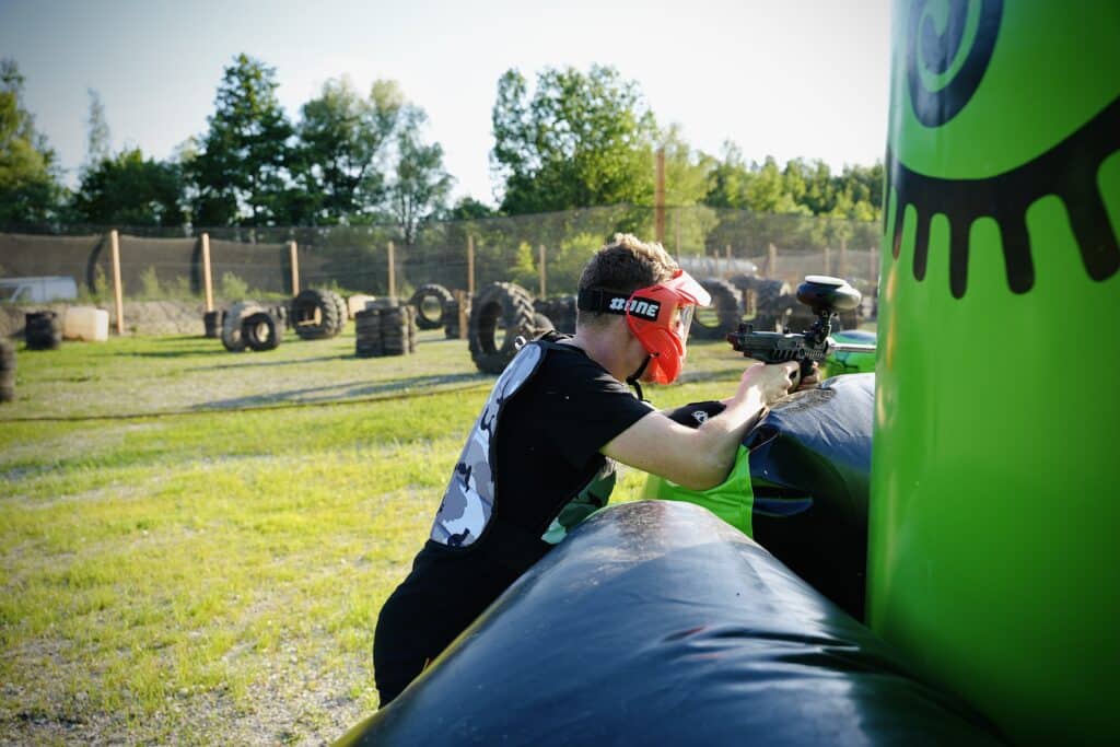 Joueur de paintball visant derrière un obstacle gonflable sur le terrain d'Amiens Paintball