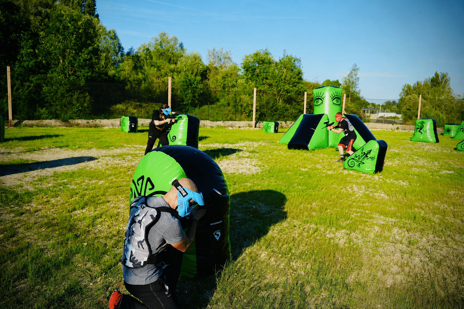 Partie de paintball à Amiens avec des joueurs derrière des obstacles gonflables sur le terrain d'Amiens Paintball